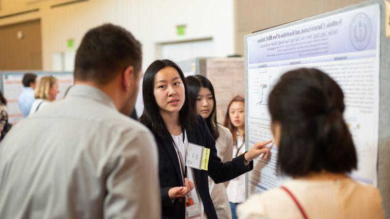 a student presents a poster at the Research & Creativity Showcase