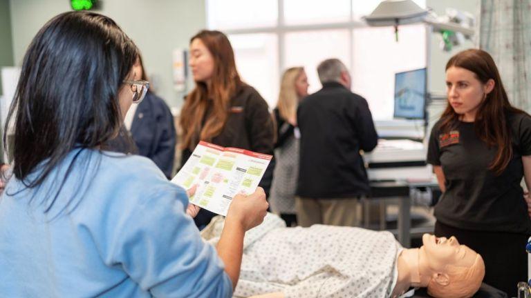 Image shows a student reviewing instructions in clinical skills lab