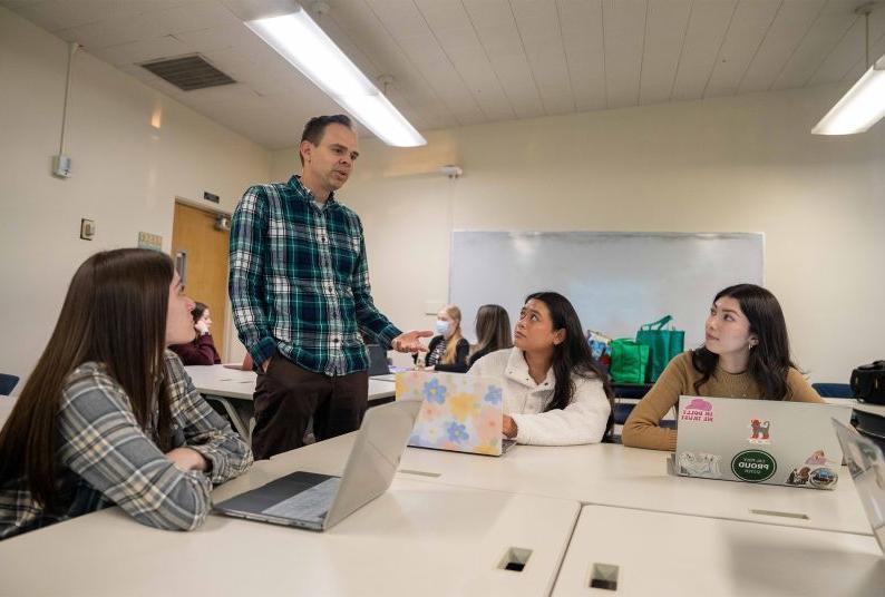 a professor works with a group of students