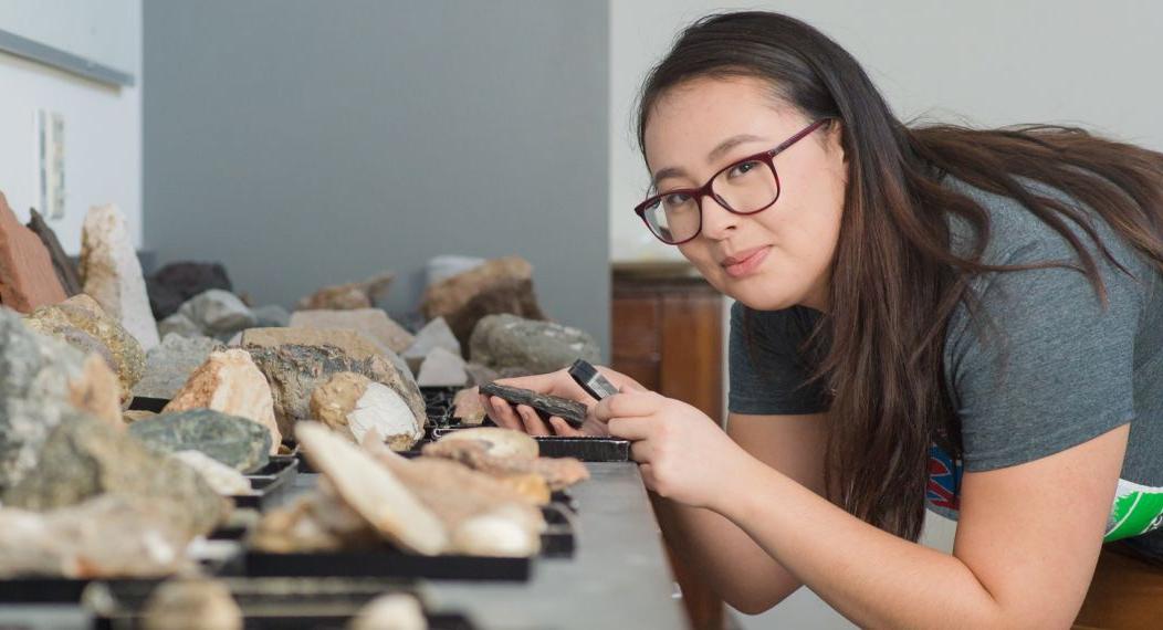 Student studying rocks in classroom