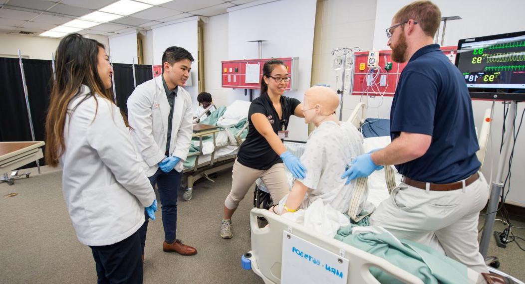 Physical therapy, pharmacy and speech language pathology students run through patient case studies in the simulation lab as part of an interprofessional education program