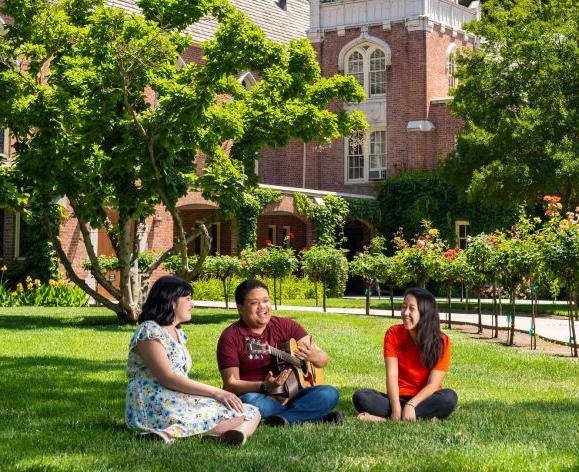 students sitting on lawn next to Morris Chapel