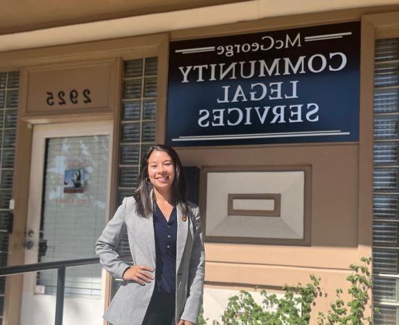 A woman poses for a photo outside of a building